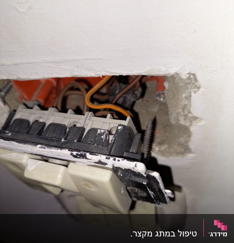 שקע חשמלי פתוח עם חוטים חשופים בקיר